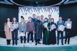 Gruppe von Menschen auf einer Bühne mit Blumensträußen und Urkunden, vor einem "Youth Solar Awards 2019"-Plakat.