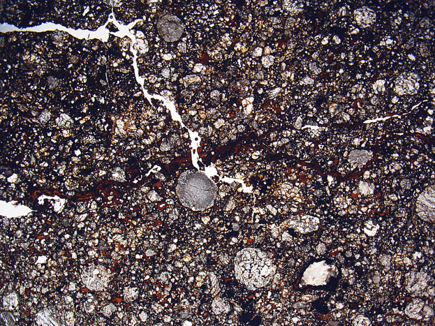 Nahaufnahme einer gesprungenen, schmutzigen Straße mit einer rauen, unebenen Oberfläche.