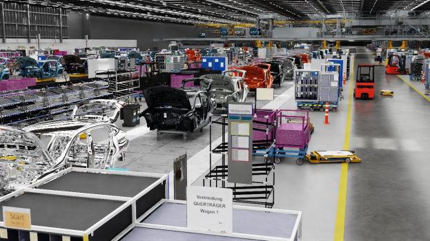 Große Fabrik mit mehreren Autos auf einer Fertigungsstraße, Metallstrukturen an den Seiten, einer Wand im Hintergrund und Deckenlampen; Volkswagen-Werk in Deutschland durch sichtbaren Text angegeben.