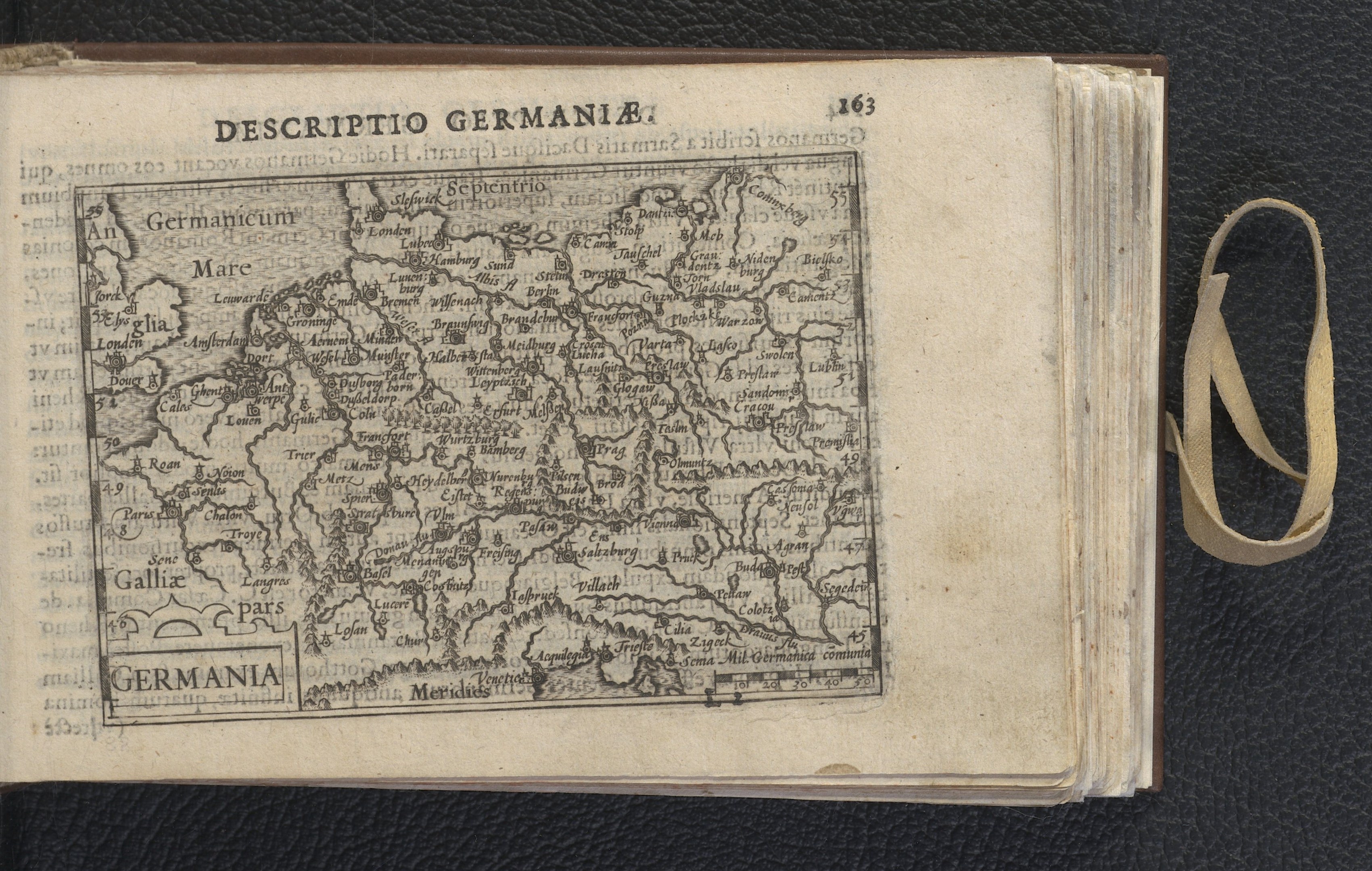 Offenes Buch mit einer historischen Deutschlandkarte und Text auf einer schwarzen Oberfläche.