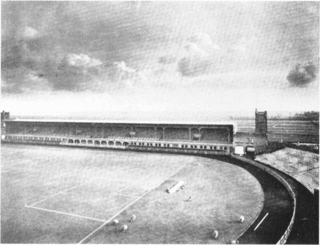 Schwarzes und weißes Foto eines Fußballfeldes mit einem Stadion, das von Bäumen umgeben ist und einen bewölkten Himmel hat, mit dem Text "Stoke City Football Club" unten.