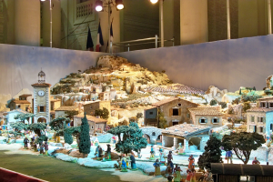 Ausstellung eines detailgetreuen Krippenmodells mit Figuren, Strukturen und beleuchteten Elementen in festlicher Atmosphäre.