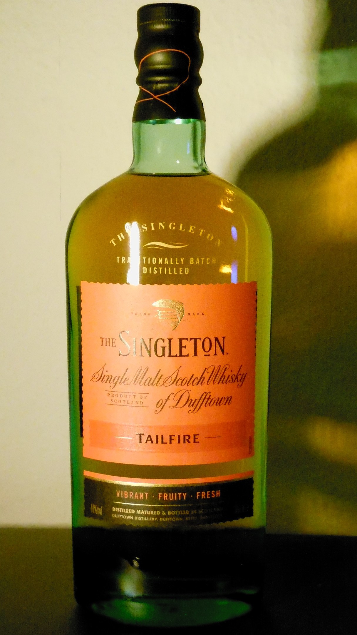 Tiefes Bernsteinflasche von Singleton of Dufftown Tailfire Single Malt Scotch Whisky mit einem schwarzen Etikett, das ein Wappen mit einem Löwen und einer Burg zeigt.